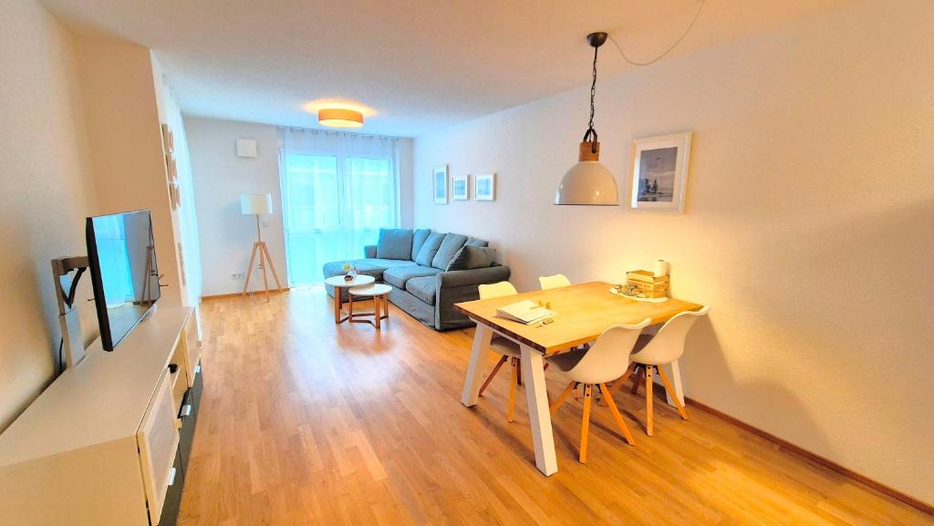 salon ze stołem i kanapą w obiekcie BodenSEE City Apartment Friedrichshafen CASA GRAF w mieście Friedrichshafen