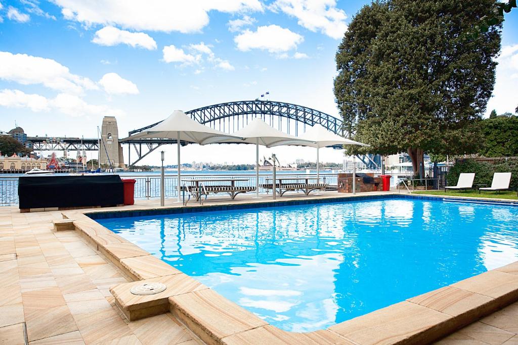 a large swimming pool with a view of the sydney harbour at Harbourside Apartment with Spectacular Pool in Sydney