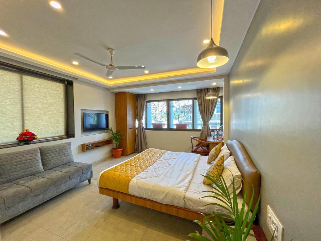 a bedroom with a bed and a couch at Hotel Parklane in Mumbai