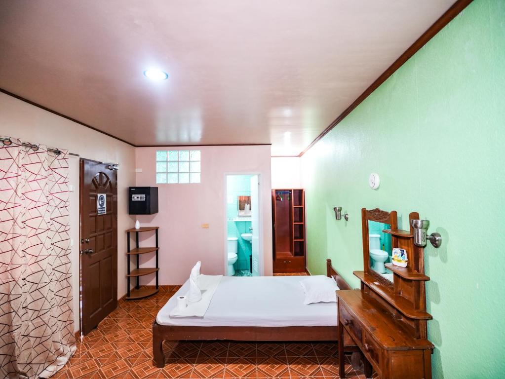 ein Schlafzimmer mit einem Bett und einer grünen Wand in der Unterkunft Gracias Inn in Boracay
