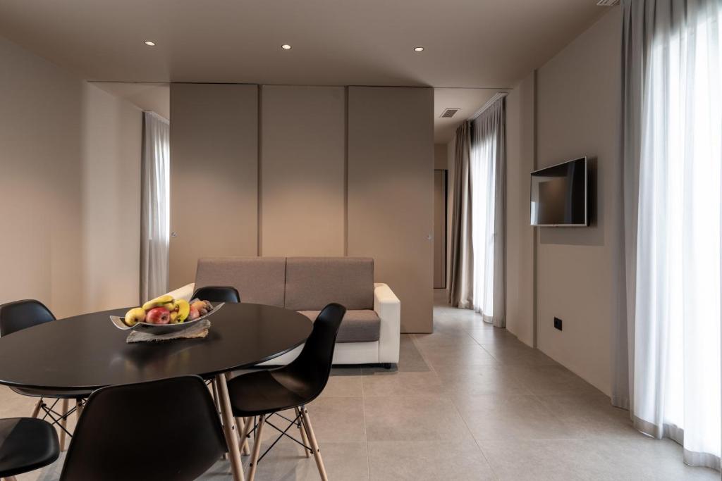 - un salon avec une table, des chaises et un canapé dans l'établissement Amare Suite & Apartments, à Bellaria-Igea Marina