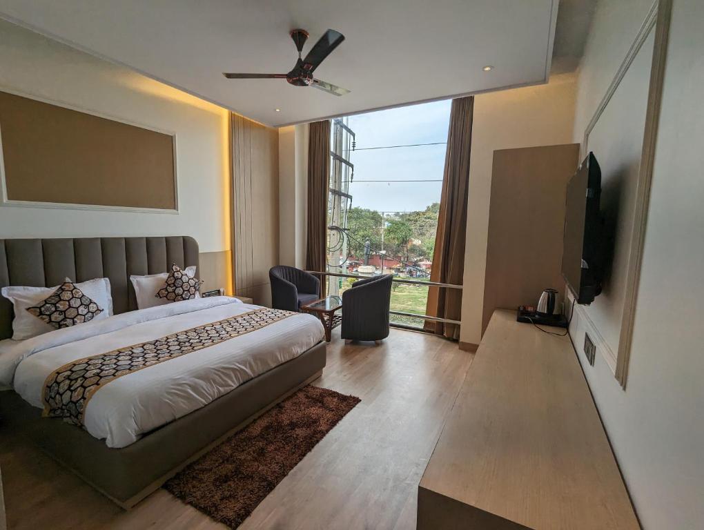 ein Schlafzimmer mit einem Bett und einem großen Fenster in der Unterkunft HOTEL CASA ROYALE in Amritsar