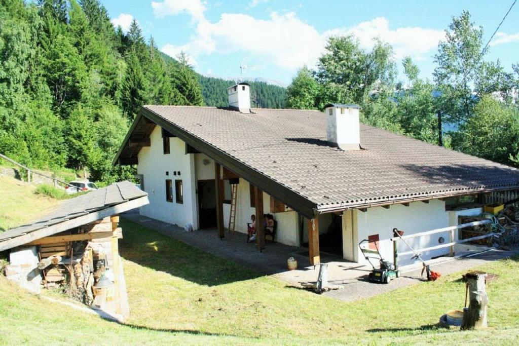 a small white house with a gambrel roof at Eco Chalet Nonno Silvano in Bedollo
