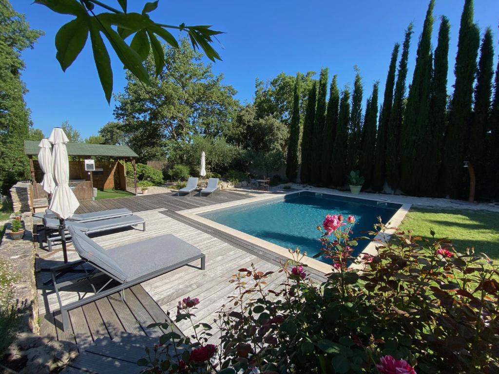 - une piscine dans une cour avec des chaises et un parasol dans l'établissement Pierres-Blanches, à Venasque