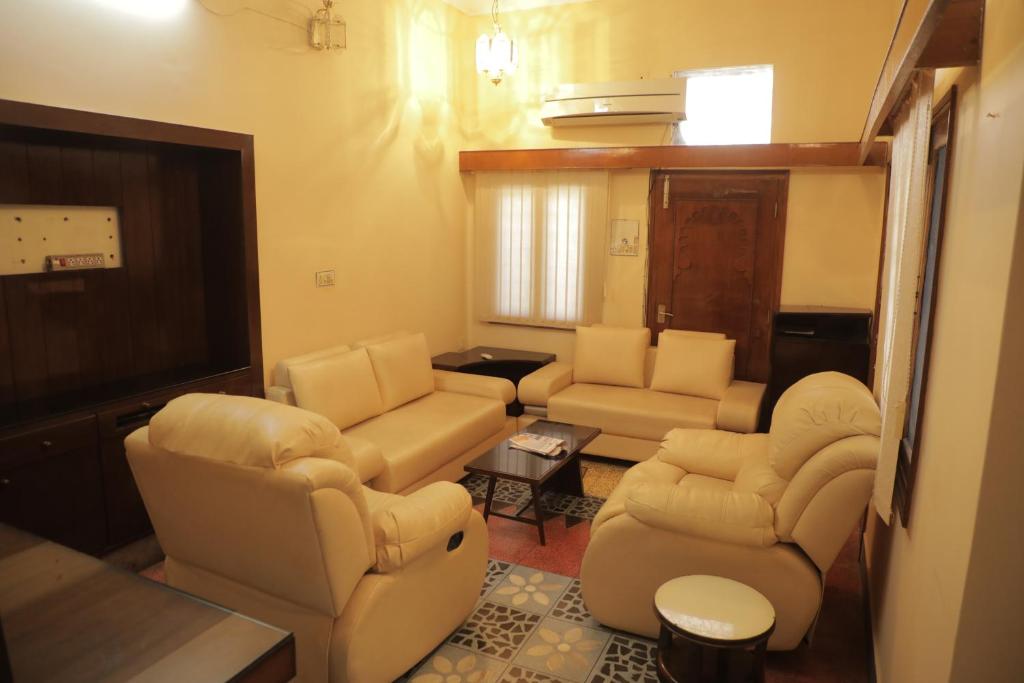 Authentique Home Abode - 3 Bedroom & Living في أودايبور: غرفة معيشة مع كراسي كنب وتلفزيون