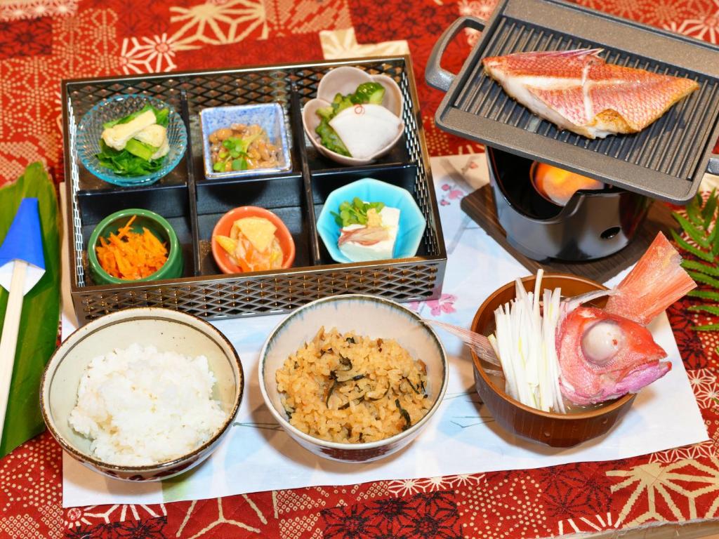 una mesa cubierta con tazones de comida y arroz en HOTEL KANALOA en Tokashiki