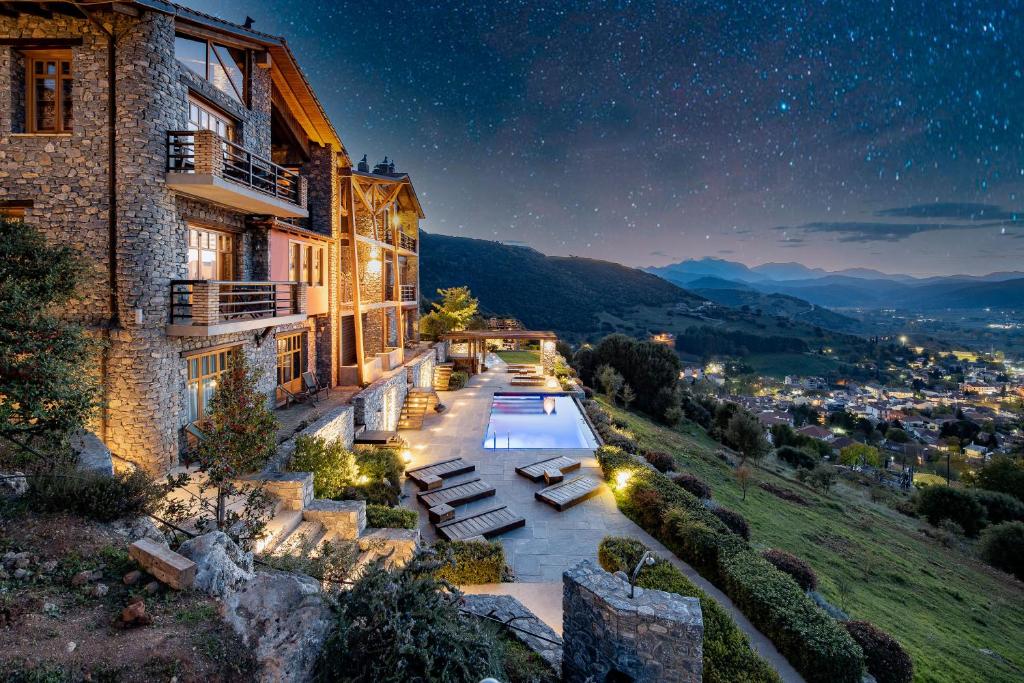 a building with a swimming pool at night at Chalet Azanias in Kalavrita