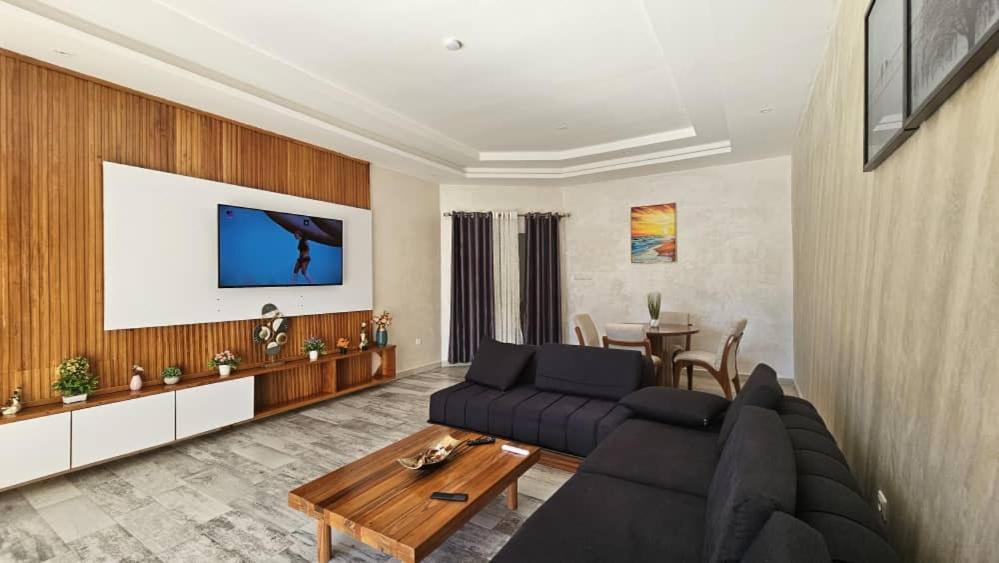 ein Wohnzimmer mit einem Sofa und einem Tisch in der Unterkunft Résidence du goût in Kribi