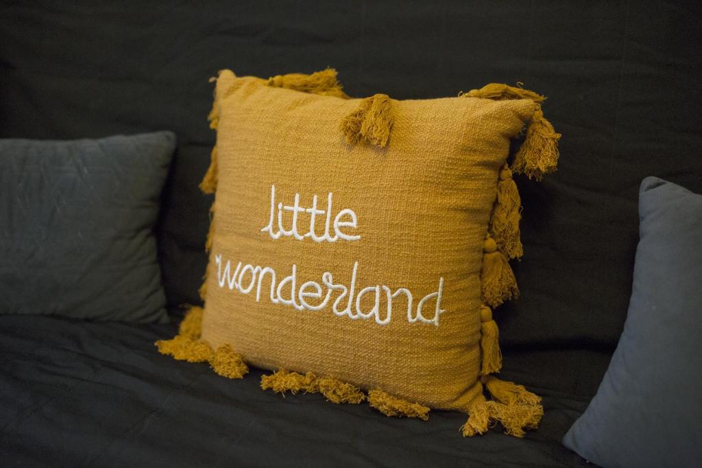 a yellow pillow with the words little wonderland on it at Le Médiéval in Clermont-Ferrand