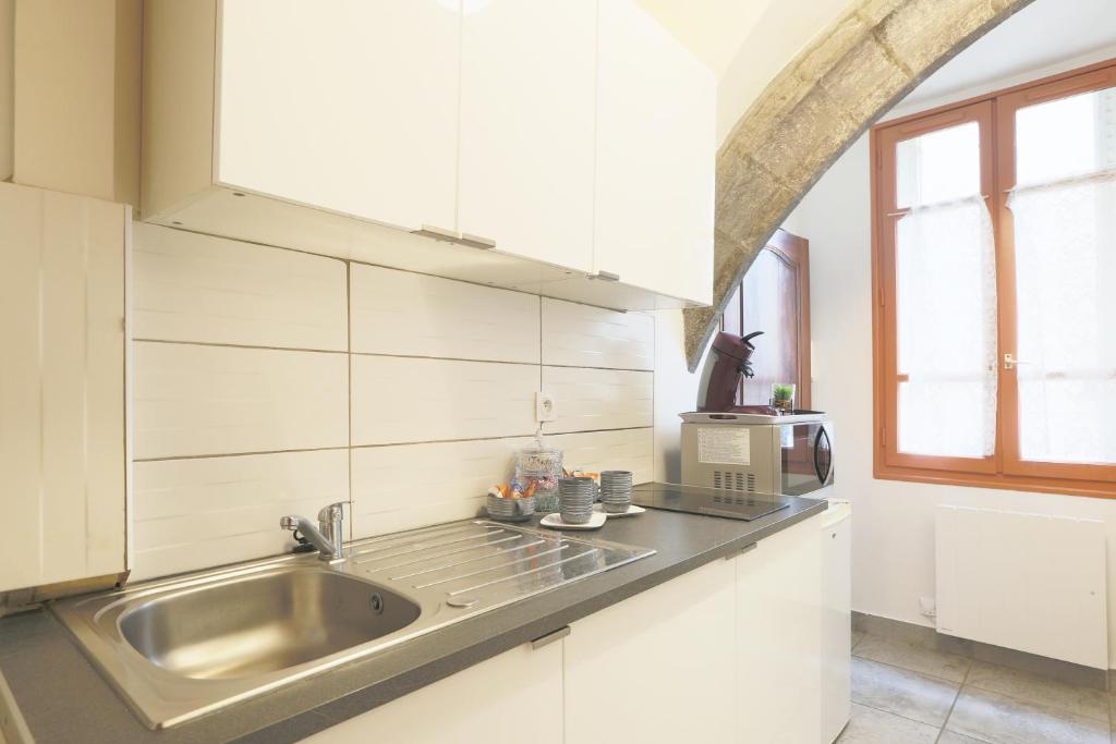 a kitchen with a sink and a microwave at Le Médiéval in Clermont-Ferrand