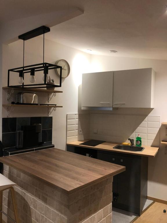 eine Küche mit weißen Schränken und einer Arbeitsplatte in der Unterkunft Little Snug in Toulouse