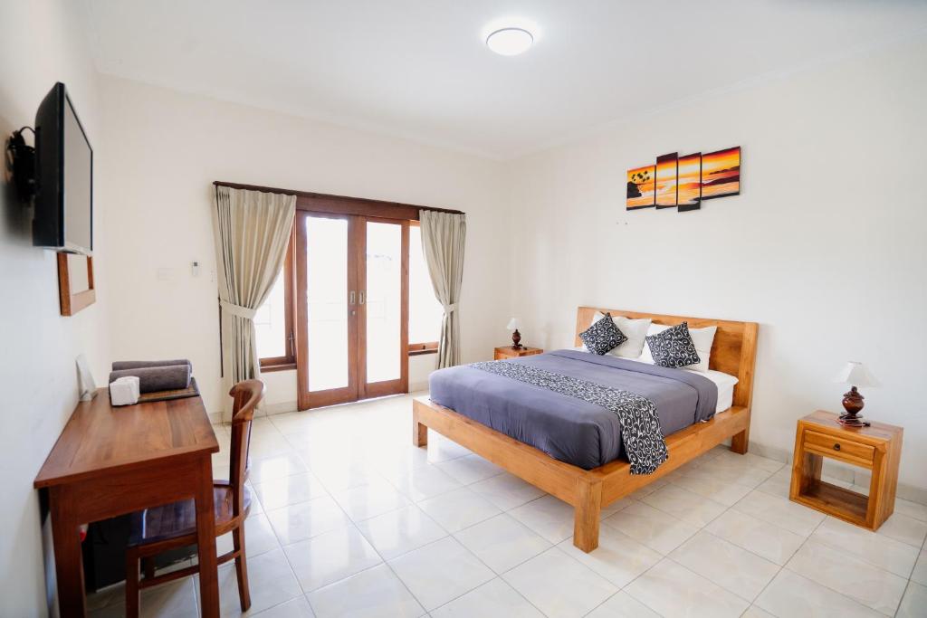 Un dormitorio con una cama, un escritorio y un televisor. en Kayuma Catu Canggu, en Canggu