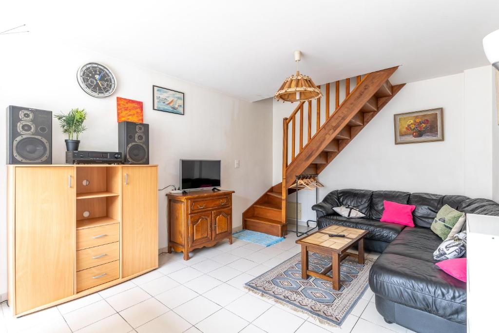 a living room with a couch and a staircase at Gîte Lauréac - Maison avec jardin in Pessac