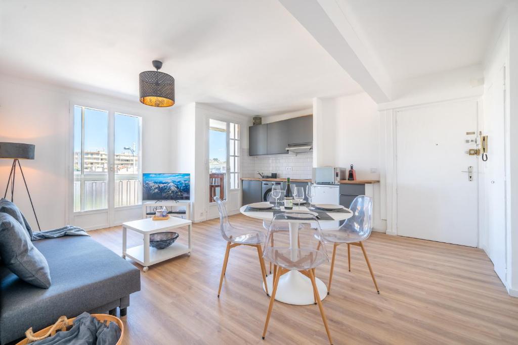 a kitchen and living room with a table and chairs at Appartement à 100m de la plage, climatisé in Cagnes-sur-Mer