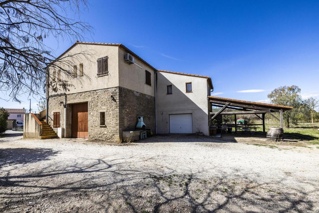 a large white barn with a large garage at Mas Jordi - Appt climatisé in Saint-André