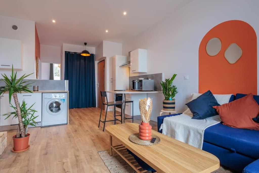 un salon avec un canapé bleu et une table dans l'établissement Appart Jean Jaurès - 2 min gare - centre ville, à Bourg-en-Bresse