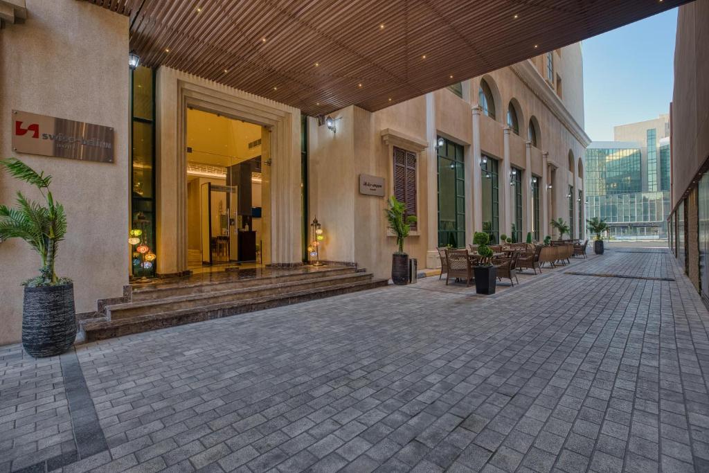 an empty walkway in a building with plants on it at Swiss-Belinn Doha in Doha