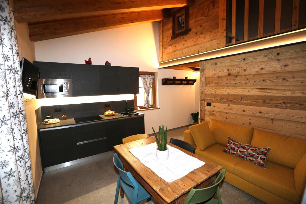 a living room with a table and a kitchen at L'abri en ville in Aosta