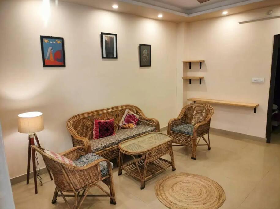 a living room with wicker furniture and a table and chairs at The Anand with Ganga View and Rooftop Cafe in Rishīkesh
