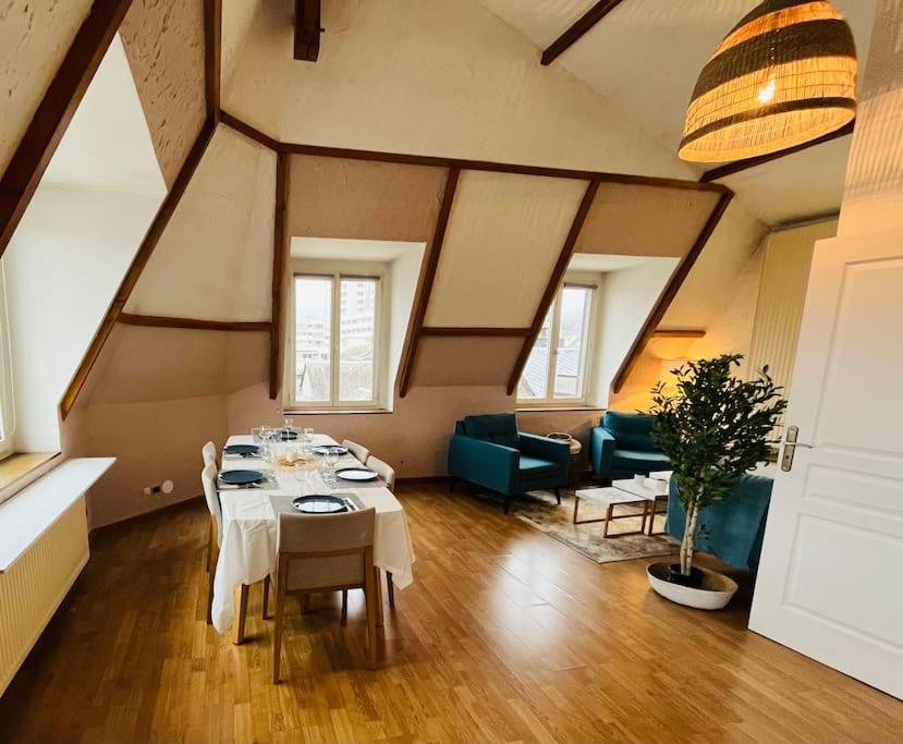 een kamer met een tafel met stoelen en een bank bij Superbe Duplex pour 8/10 personnes in Rouen