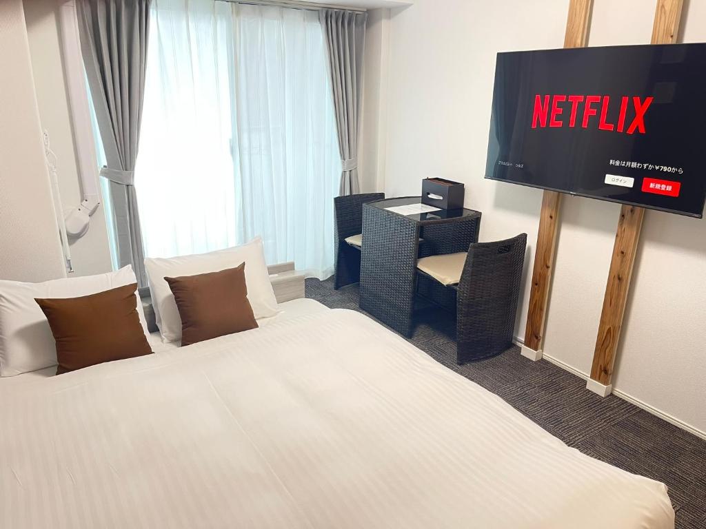 Habitación de hotel con cama y TV en COCOSTAY銀山町リバーサイド,COCOSTAY Kanayamacho riverside, Great location river view-5 min walk from the nearest station en Hiroshima