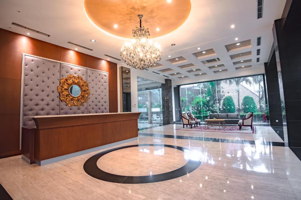 a lobby with a reception desk and a chandelier at The Mirah Bogor in Bogor