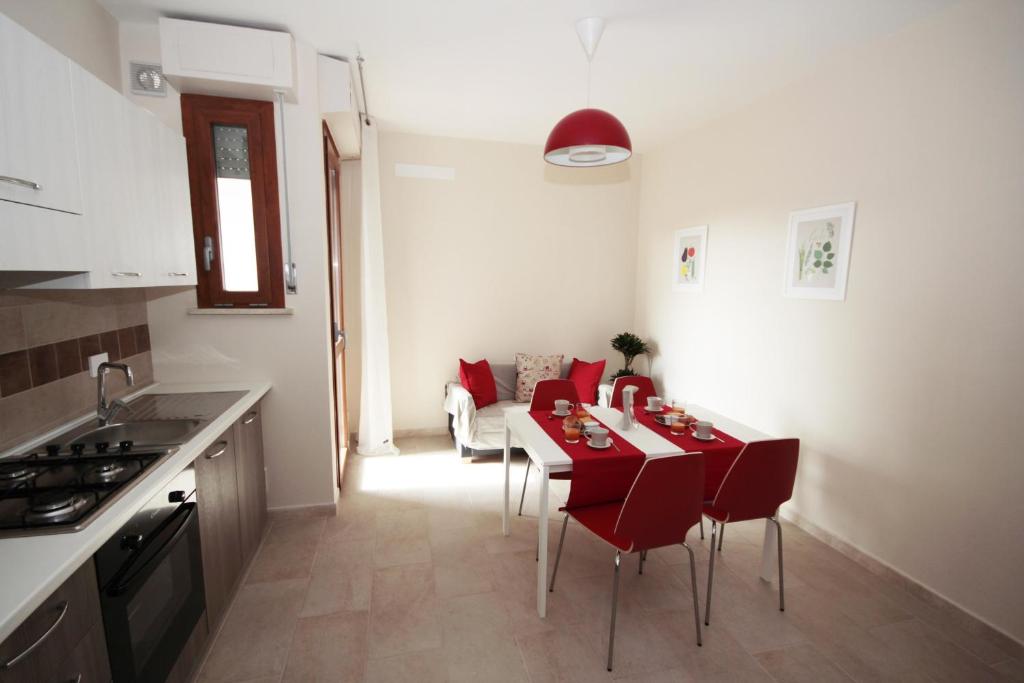 eine Küche und ein Wohnzimmer mit einem Tisch und roten Stühlen in der Unterkunft A Pochi Passi in Pisa