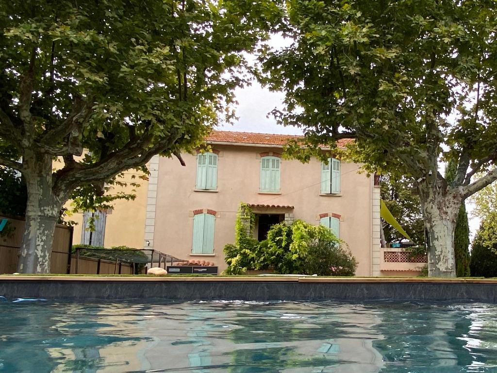 une piscine devant une maison dans l'établissement Superbe villa avec piscine, jardin et terrasse aux portes d'Aix en Provence, à Aix-en-Provence