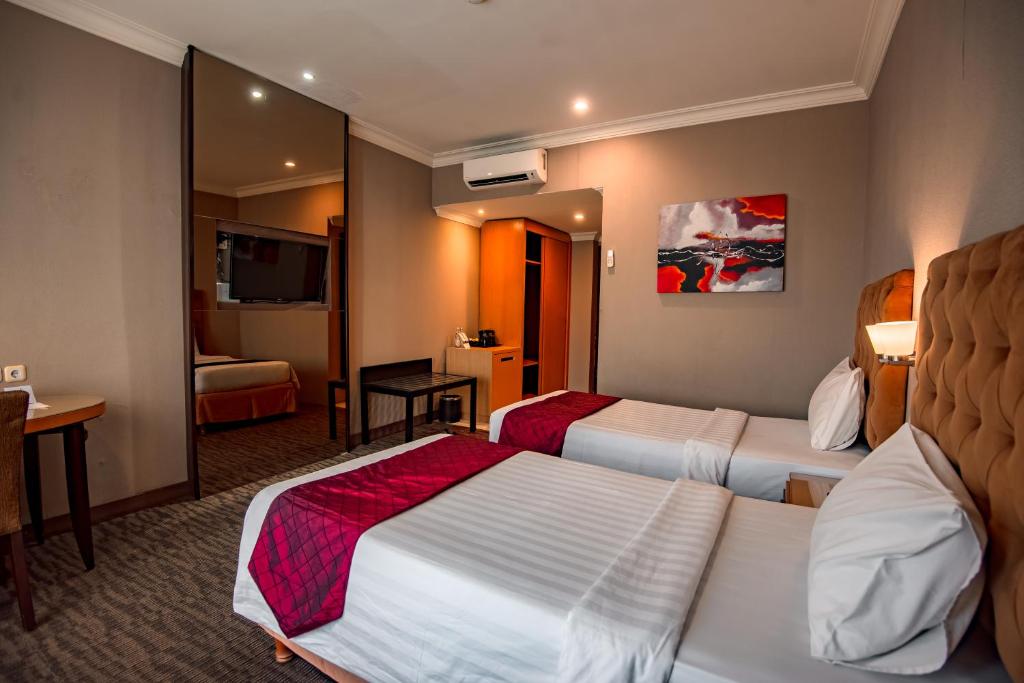 Postel nebo postele na pokoji v ubytování The Mirah Hotel Bogor