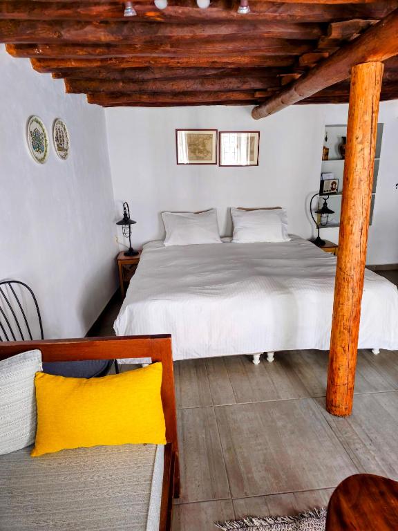 una camera da letto con un letto bianco e un soffitto in legno di Keresbino Hydra Art Suite a Hydra