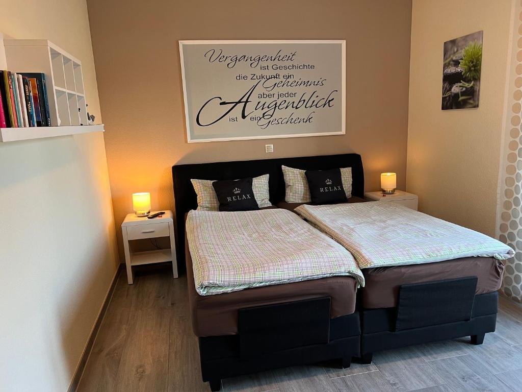 a bed in a bedroom with two lamps on the floor at Ferienwohnung Nordsee in Pewsum