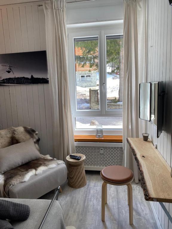 a living room with a couch and a window at Appartamento Kern-Sciare A Portata Di Mano- in Madesimo
