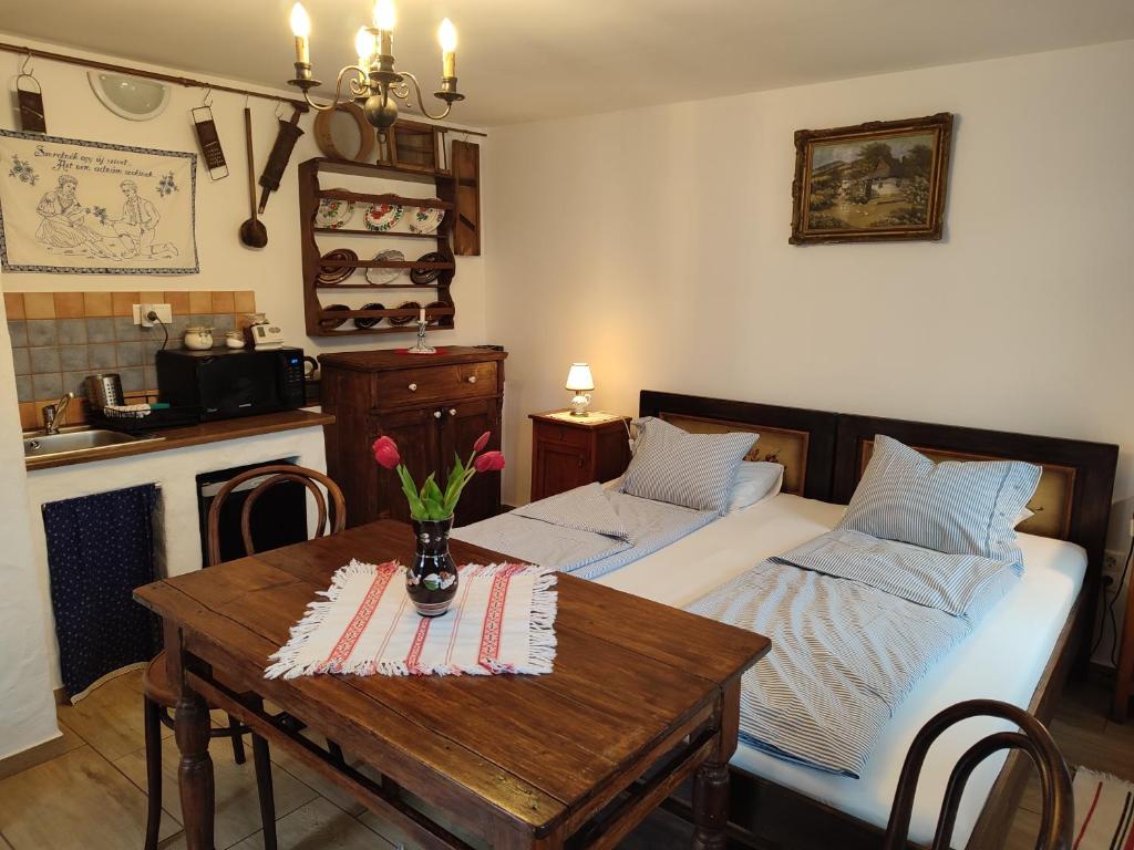 Un dormitorio con una cama y una mesa con flores. en Szent Iván Vendégház en Tata