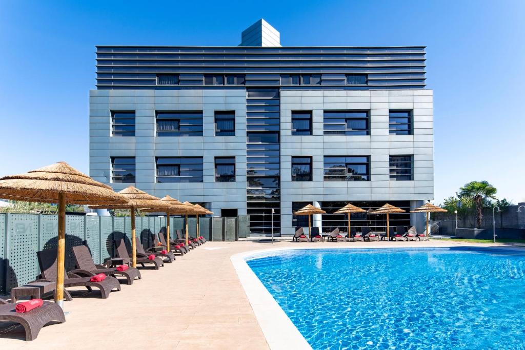 a hotel with a swimming pool with chairs and umbrellas at Hotel Nuevo Boston in Madrid