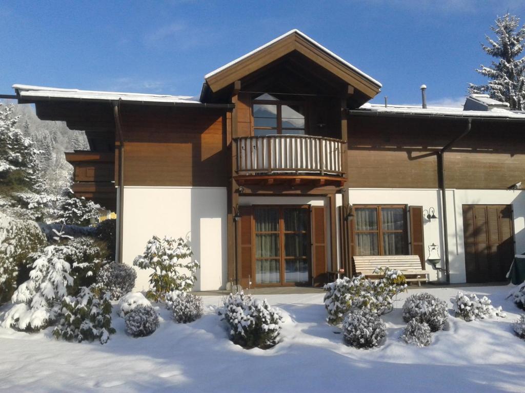 ツェル・アム・ゼーにあるSki & Golf Apartment Zell am Seeの雪の中のバルコニー付きの家