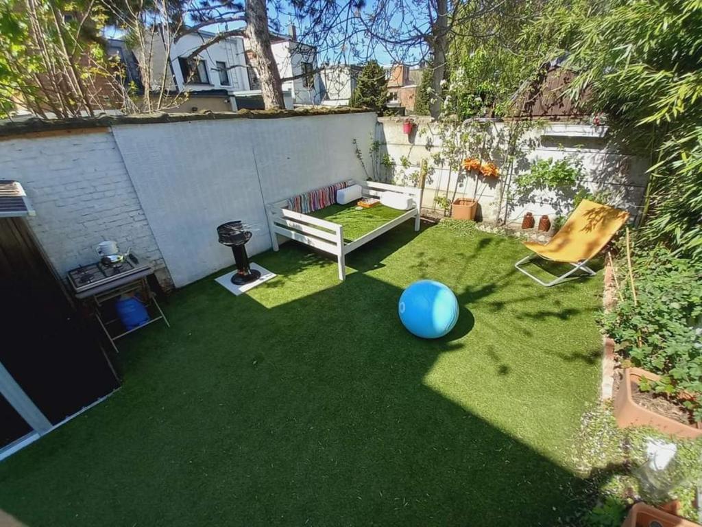 安特衛普的住宿－Rose huisje，草地上带长凳和蓝色球的花园