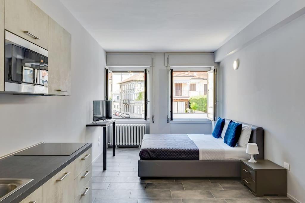 a bedroom with a bed and a kitchen with a window at Appartamento Mango - Affitti Brevi Italia in Lecco