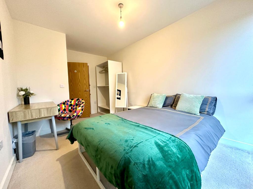 a bedroom with a large bed and a desk at Peaceful shared flat 30mins Central London in Colindale