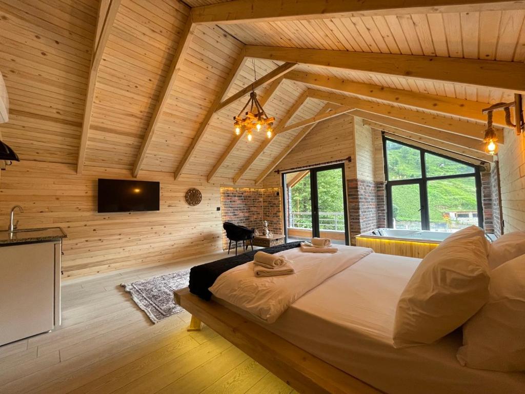 a bedroom with a large bed in a room with wooden walls at Watersıde Bungalov in Çamlıhemşin