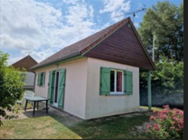 een klein huis met een bank in de tuin bij MAISON Au LAC DU DER '' LES COCCINELLES 41 '' in Giffaumont