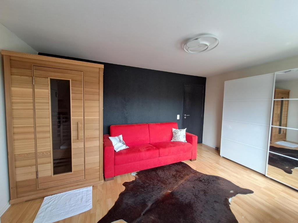 Sofá rojo en una habitación con pared en Sweet home, en Tervuren