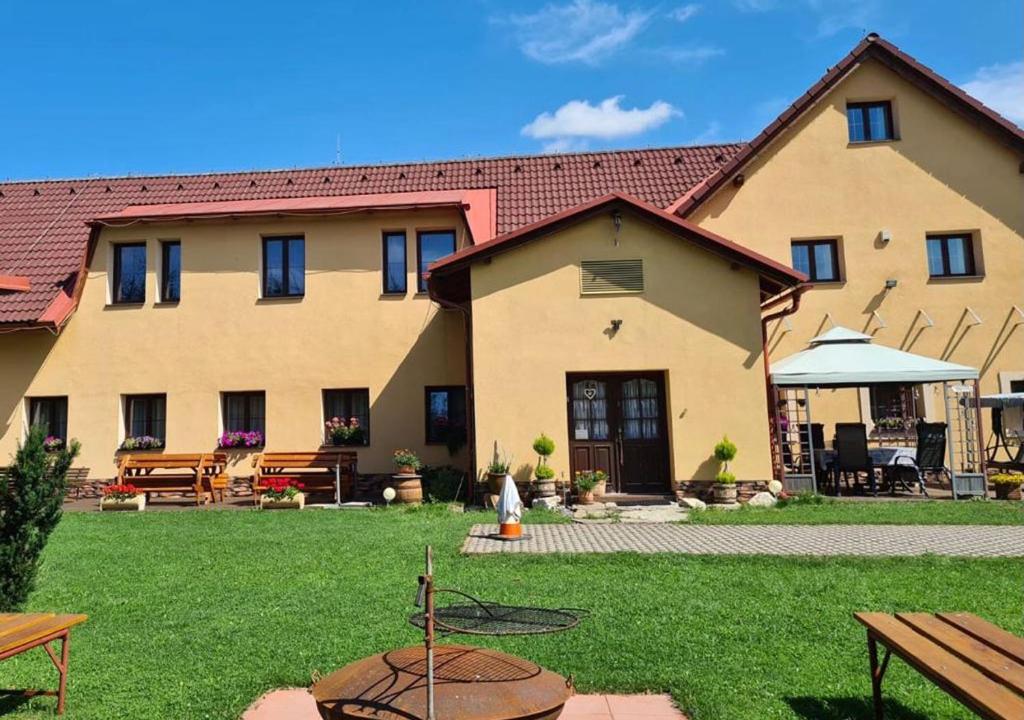 a large building with a yard with benches and tables at Rezidence Lipka in Králíky