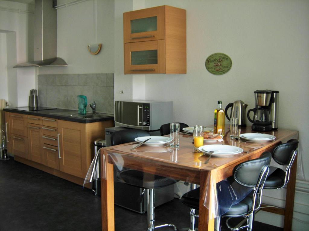 エピナルにあるSweethome-Epinalのキッチン(木製テーブル、いくつかの椅子付)