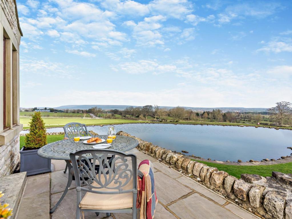 un patio con mesa y sillas junto a un estanque en 1 Bed in Barnard Castle 94454, en Startforth
