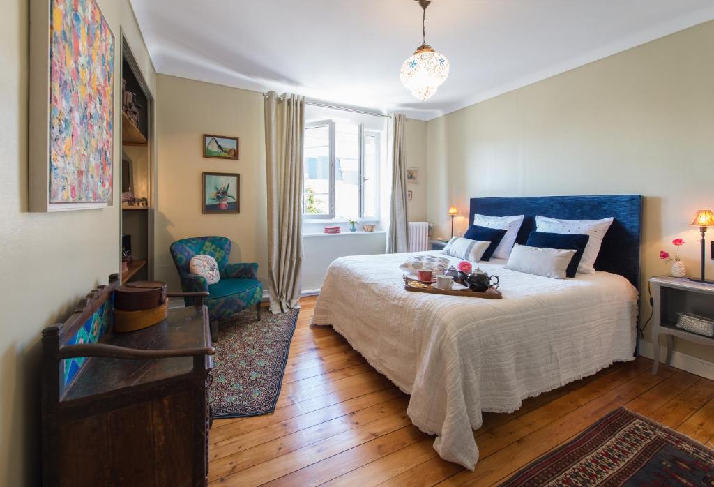 a bedroom with a large bed with a blue headboard at La Mancelle - Chambre d'hôtes in Le Mans