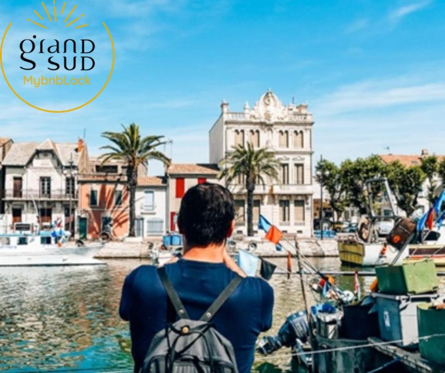 a man on a boat in the water with a backpack at Les Pieds dans le Sable in Le Grau-du-Roi