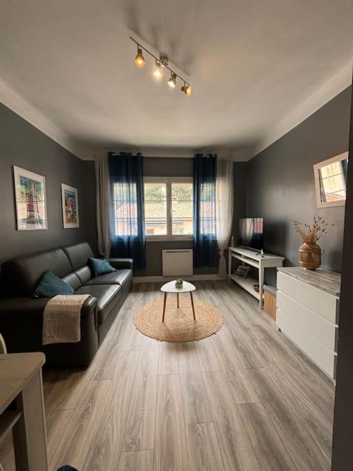 un salon avec un canapé et une table dans l'établissement Appartement bord de plage, à Cassis