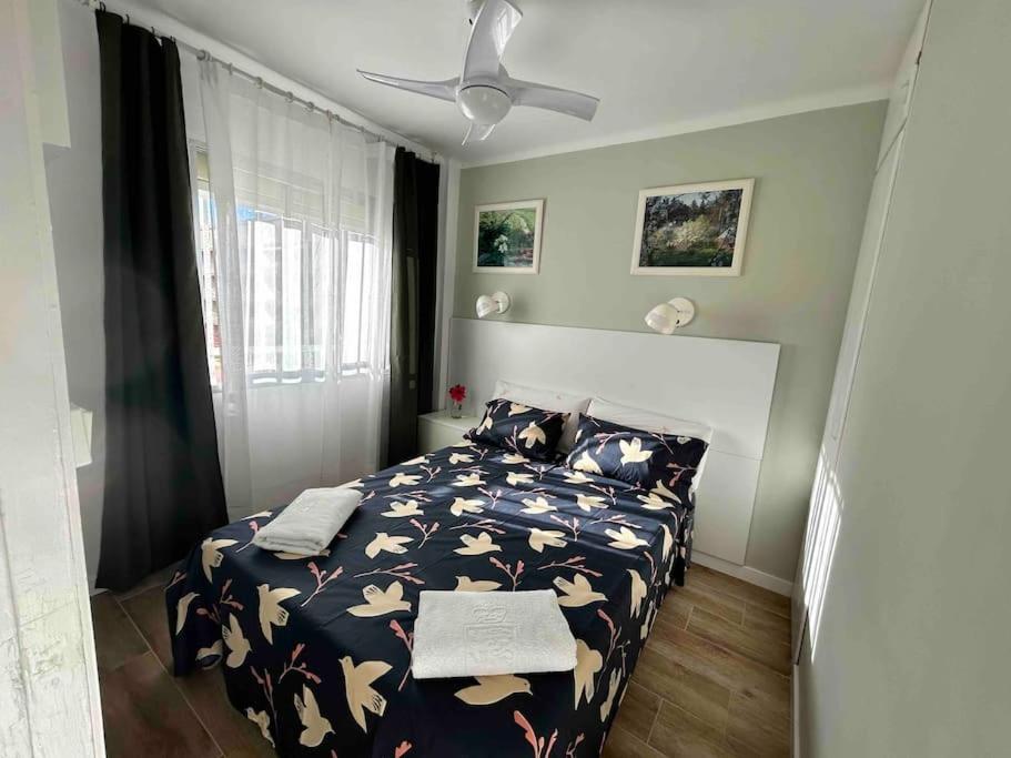 een slaapkamer met een bed en een plafondventilator bij Apartment “Africa” in Segur de Calafell