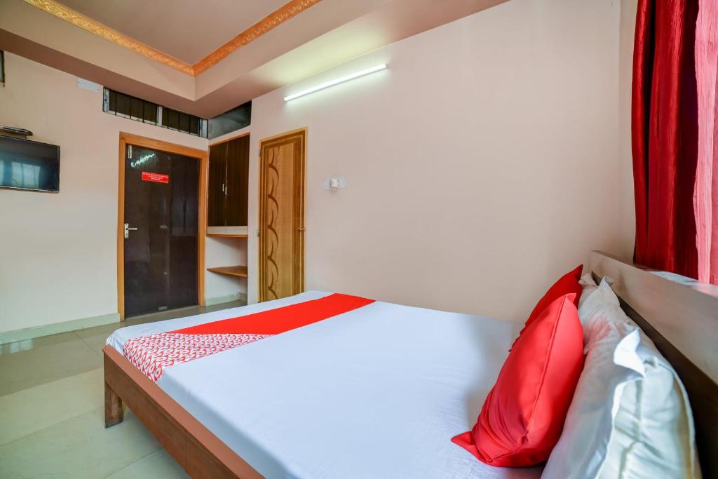 um quarto com uma cama com almofadas vermelhas em Flagship Hotel Mayur em Dalaigaon