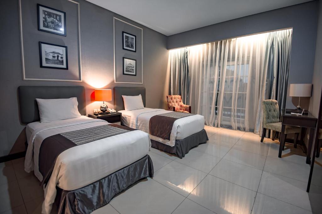 Postel nebo postele na pokoji v ubytování The Mirah Hotel Bogor